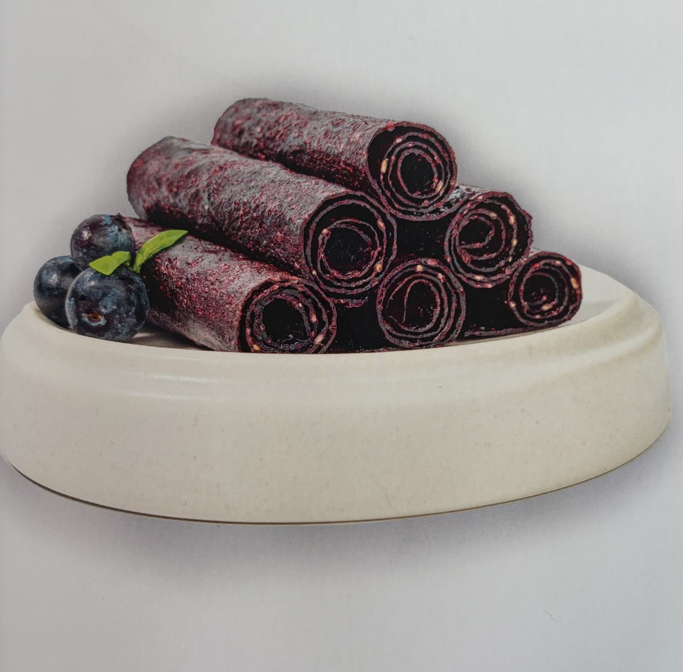 Dark berry fruit rolls pictured with fresh berries